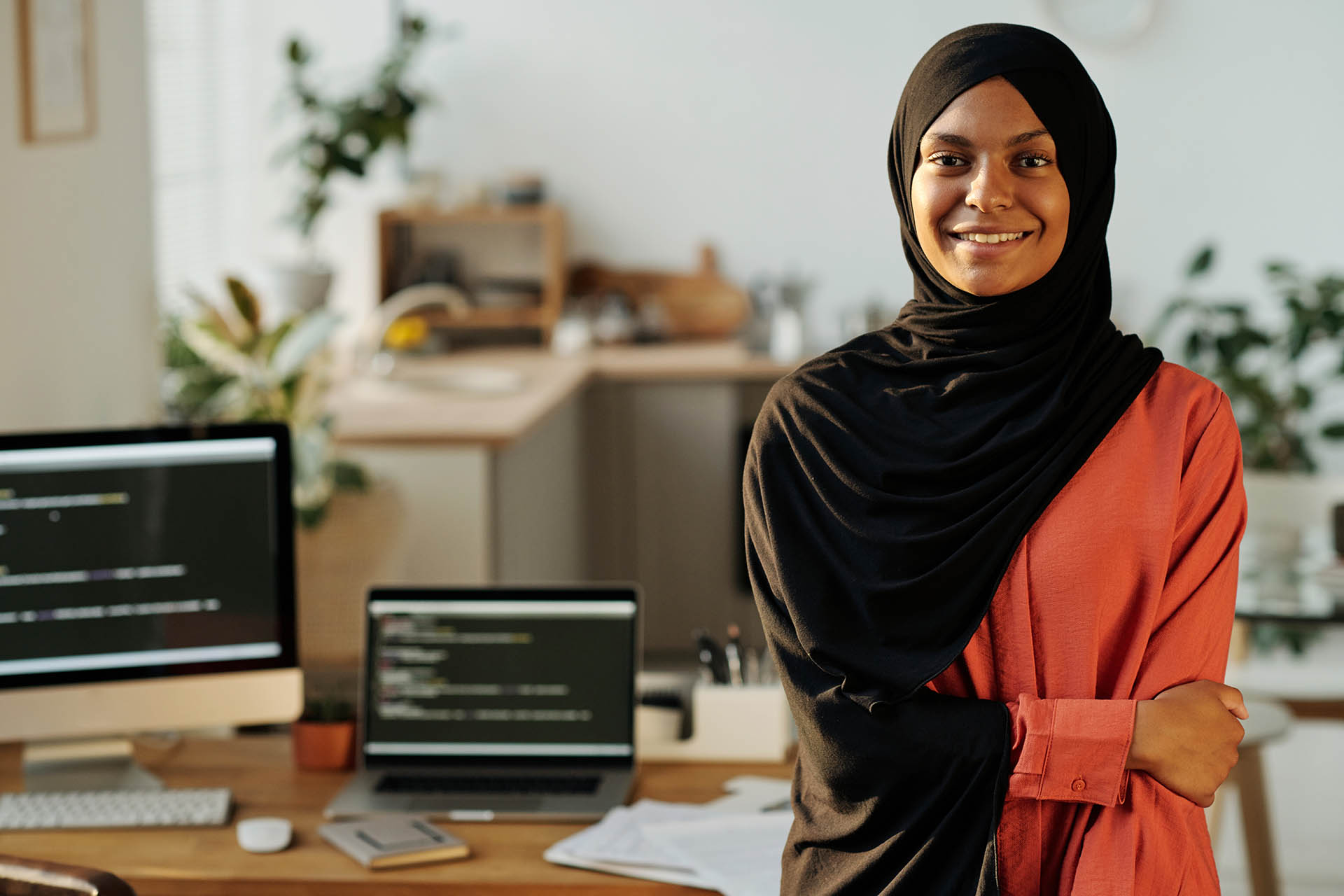 Young smiling Muslim home office worker looking at camera